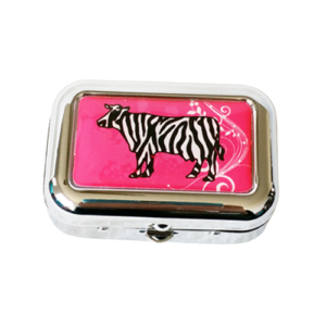 Leuk zilverkleurig zakasbakje met een afbeelding van een koe met zebrastrepen op roze achtergrond.